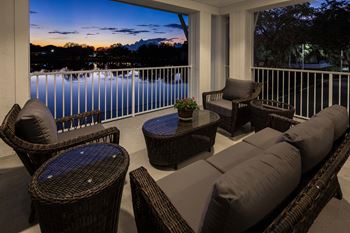 a screened in porch with wicker furniture and a table with a potted plant at Arbor Hills, Lakeland, FL